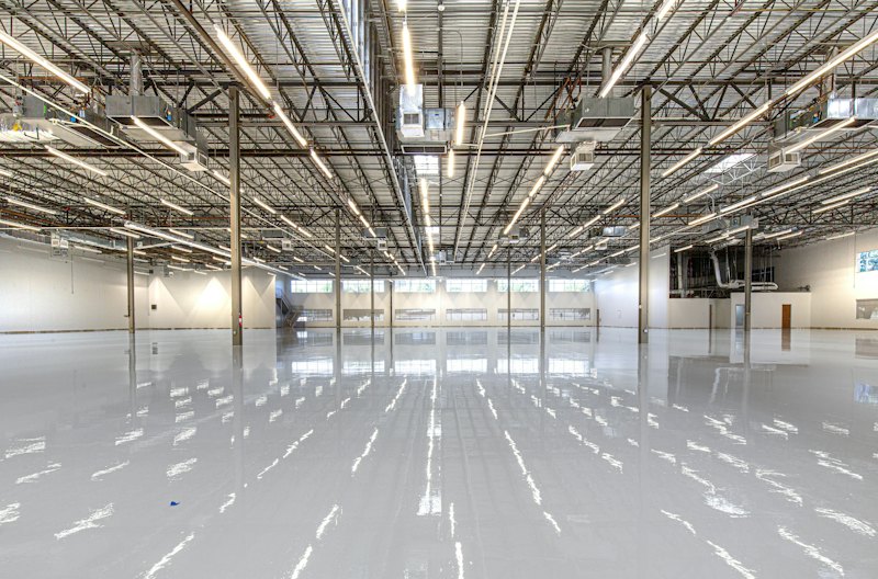 Glossy coated floor reflecting overhead lights in a large building