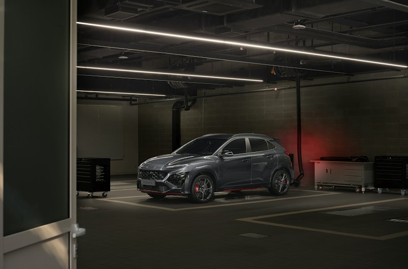 Car parked in a modern garage with a dark coated floor and striped bays